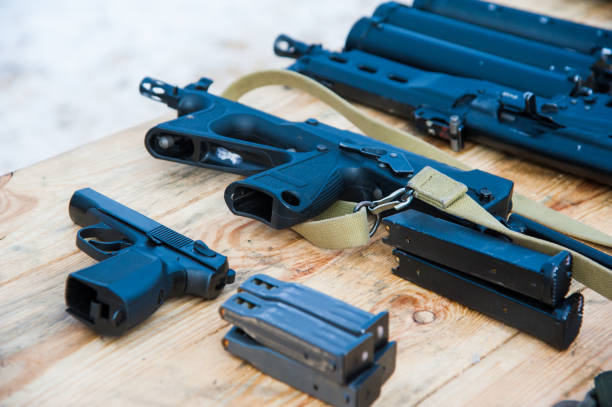 istock Gun with ammunition on wooden background 1168263625