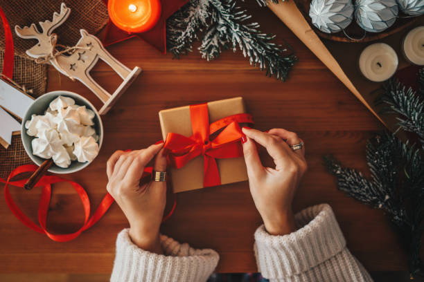 Woman wrapping Christmas gifts, overhead shot Woman wrapping Christmas gifts christmas ornament christmas decoration red religious celebration stock pictures, royalty-free photos & images