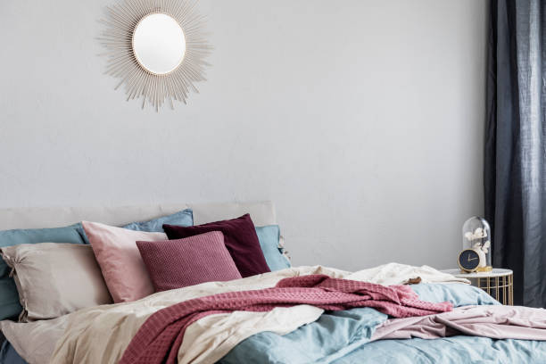 istock Sun shape like mirror on grey empty wall of comfortable bedroom interior 1168266059