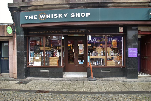 Fort William, Scotland, UK - July 17, 2019: Whisky shop in the pedestrian Zone of Fort William. West Coast of Scotland, North-west Europe.