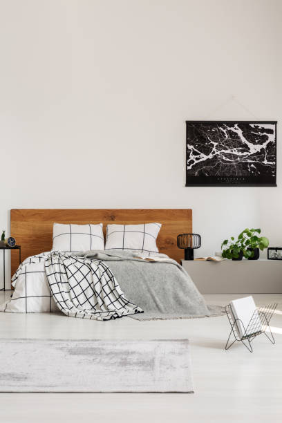 istock Copy space on white wall with black map in modern bedroom with king size bed with wooden headboard 1168267377