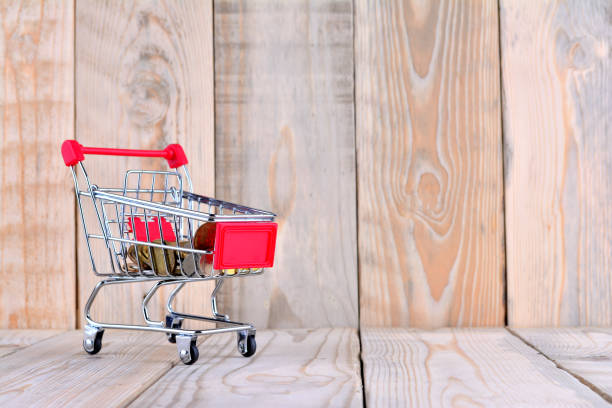 istock Single empty shopping cart on wooden background 1168272798