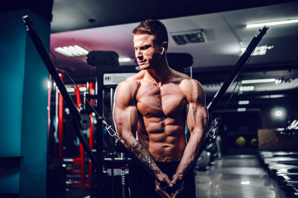 constructor de cuerpo muscular haciendo ejercicios en el gimnasio haciendo ejercicios de mosca en el pecho en la máquina de cable de alambre - músculos pectorales fotografías e imágenes de stock