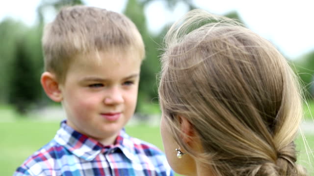 Mother scolds son, the child is sad, he bowed his head down. Close-up, slow motion