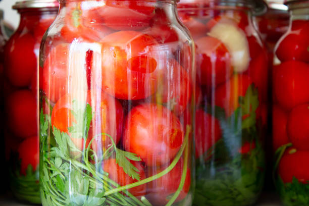 istock Pickling tomatoes in glass jars 1168277955