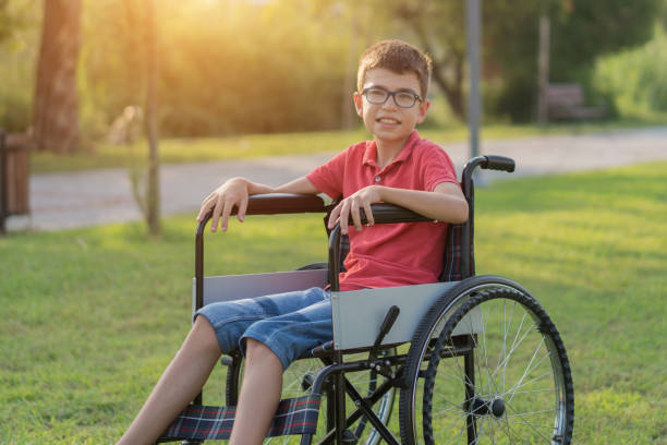 istock Young Boy Strolling in the Park with Wheelchair 1168278900