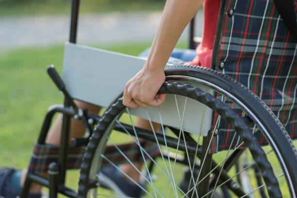 istock Young Boy Strolling in the Park with Wheelchair 1168278966