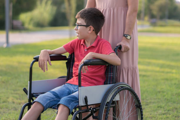 istock Mother walking with disabled son in park 1168279048
