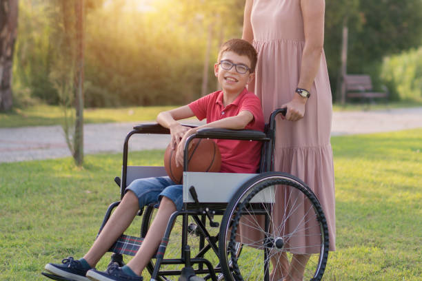istock Mother walking with disabled son in park 1168279092