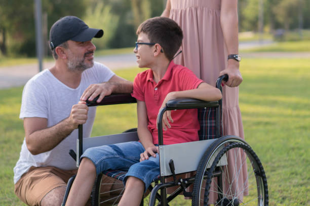 istock Happy family walking with disabled son in park 1168279285