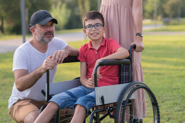 istock Happy family walking with disabled son in park 1168279385
