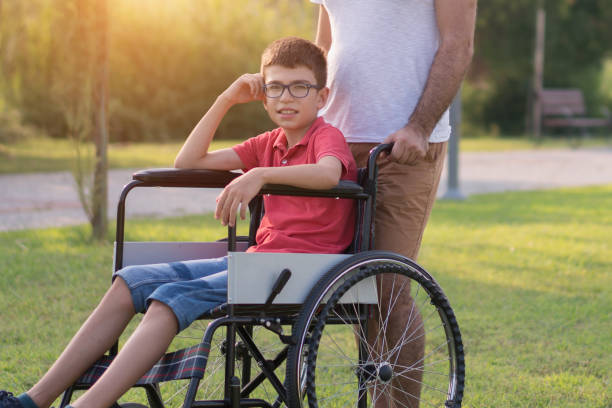 istock Father walking with disabled son in park 1168280081