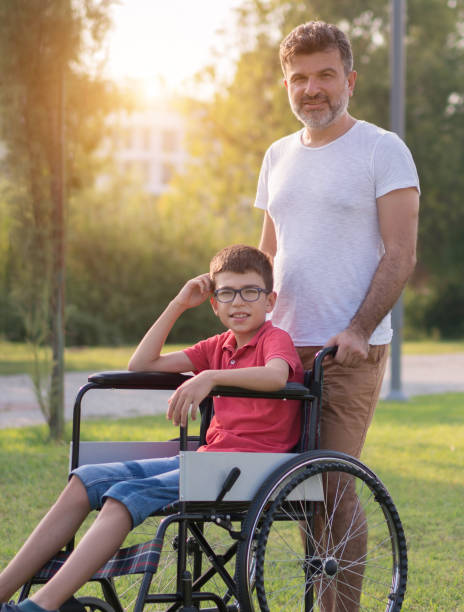 istock Father walking with disabled son in park 1168280198