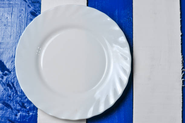 istock Empty white plate on blue and white wooden background. 1168281293