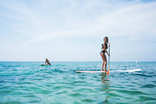 istock Freinds performing stand up paddle in ocean 1168282789