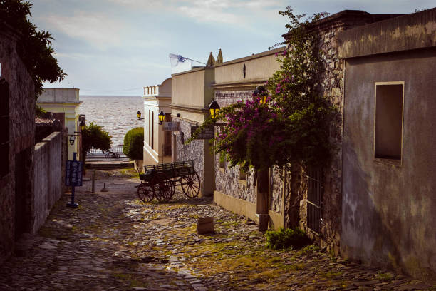 casas velhas e um ônibus na rua da cidade histórica no sudoeste de uruguai. cidade património mundial da unesco. - colonial style fotos - fotografias e filmes do acervo