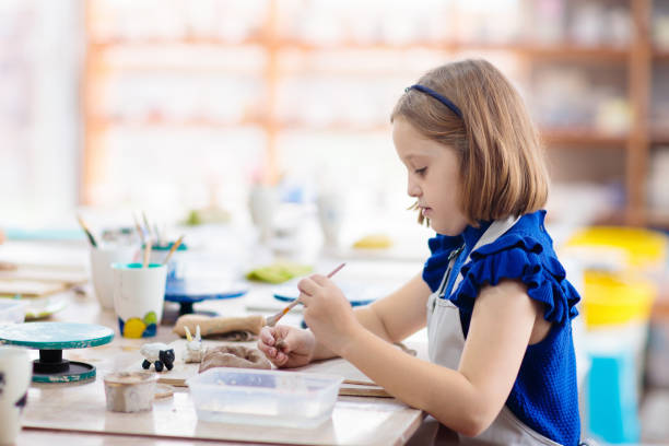 istock Child at pottery wheel. Kids arts and crafts class 1168284785