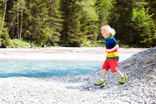 istock Child hiking in mountains. Kids at river shore. 1168285532