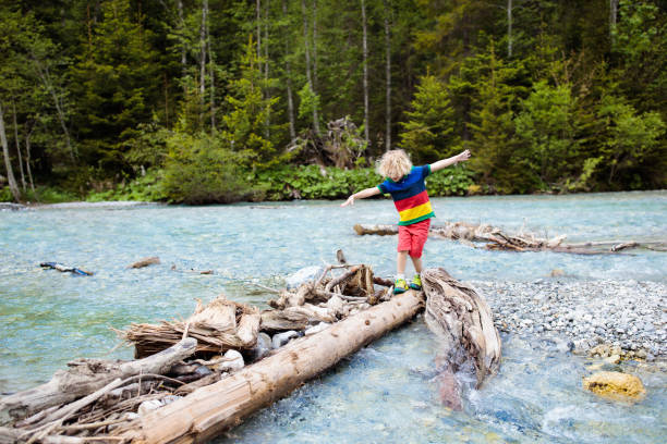 istock Child hiking in mountains. Kids at river shore. 1168286526