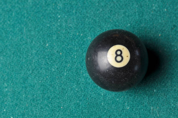istock Old billiard ball number 8 black color on green billiard table, copy space 1168287237