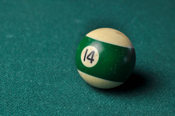 istock Old billiard ball number 14 striped white and green on green billiard table, copy space 1168287263