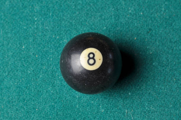 istock Old billiard ball number 8 black color on green billiard table, copy space 1168287365