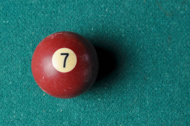 istock Old billiard ball number 7 brown color on green billiard table, copy space 1168287396