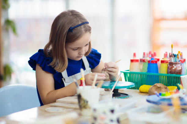 istock Child at pottery wheel. Kids arts and crafts class 1168287403
