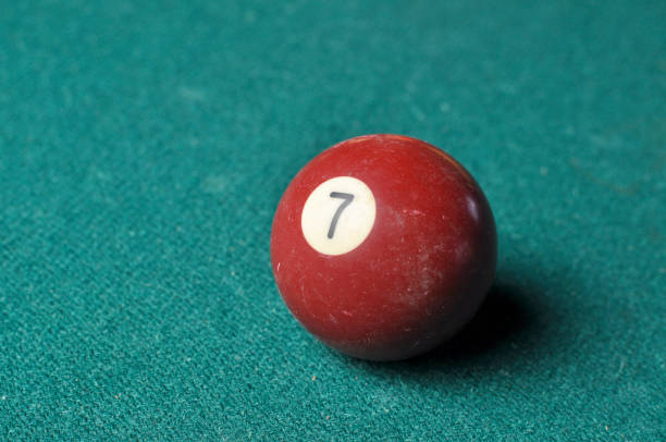 istock Old billiard ball number 7 brown color on green billiard table, copy space 1168287454
