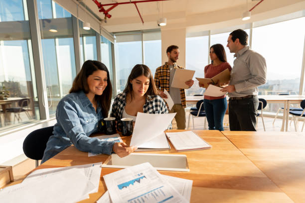 istock Female business partners looking at documents while enjoying a coffee at a coworking office 1168290473