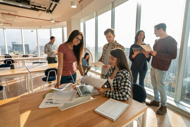 istock Team of young people working at a coworking space discussing business using paperwork and technology 1168290505