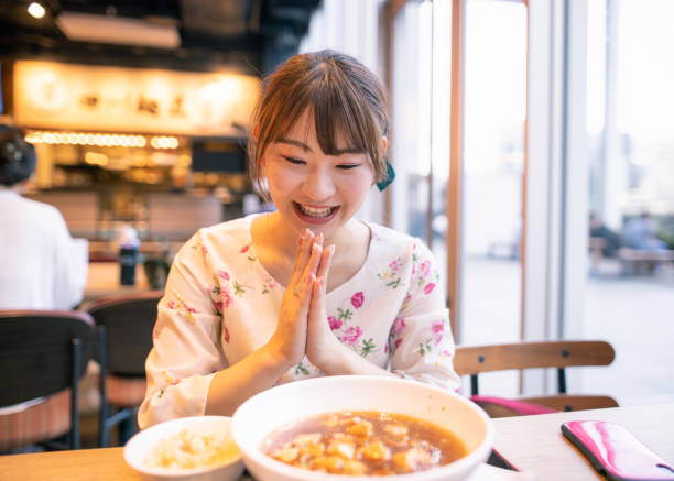 Young woman eating ramen noodle at restaurant