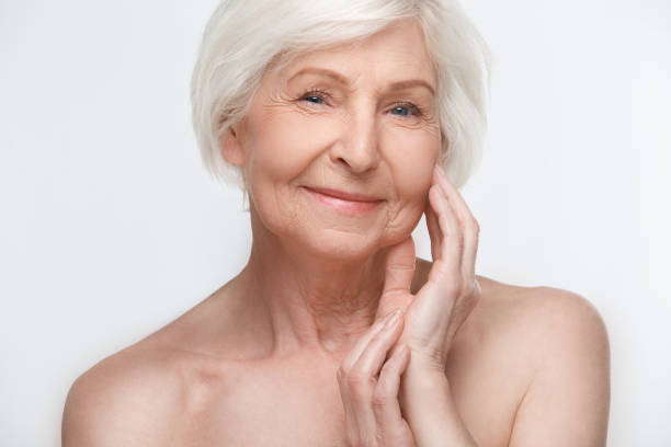 istock Senior woman studio isolated on white wall beauty concept touching face tender 1168294392