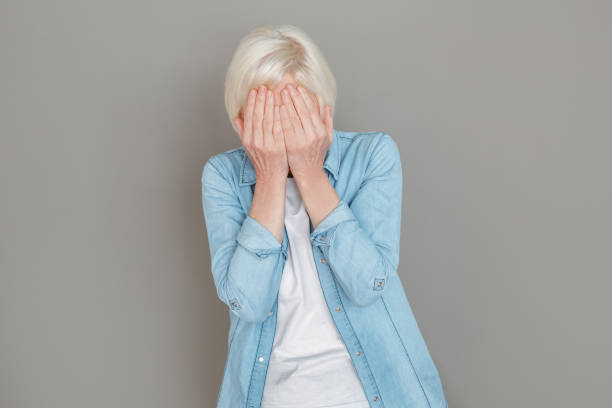 istock Senior woman in jeans jacket studio isolated on grey wall crying unhappy 1168294399