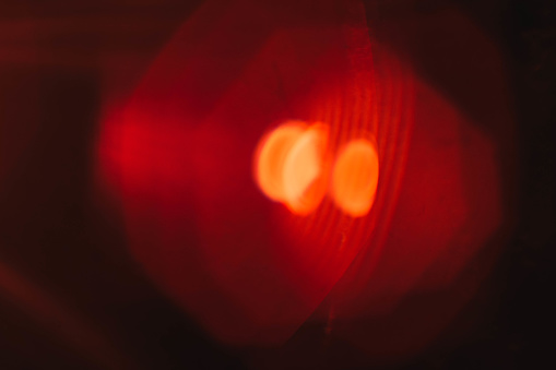 Defocused lens flare. Red headlight effect. Blur yellow spots. Abstract art background.