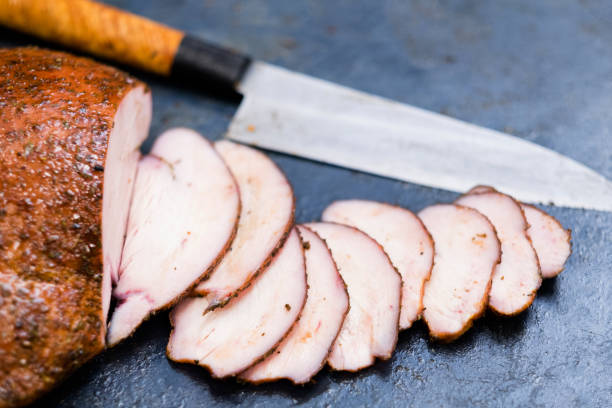 catering service sliced smoked turkey breast Catering service. Closeup of sliced smoked turkey breast and knife on kitchen table. Copy space. smoked food stock pictures, royalty-free photos & images