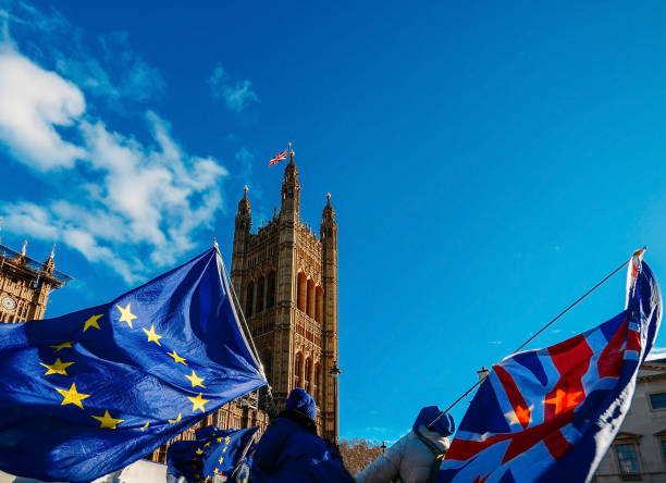 europäische union und british union jack flagge weht vor houses of parliament im westminster palace, london - victoria tower fotos stock-fotos und bilder