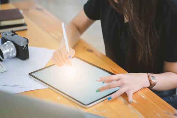 istock Young Asian graphic designer working on computor and graphics tablet in her working space 1168298750