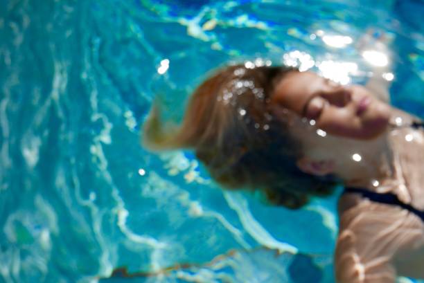 istock Girl relaxing and floating in a pool (head and shoulders) 1168304255