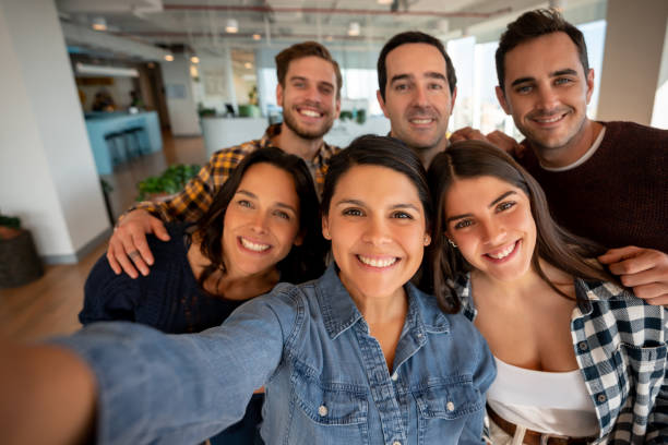 istock Group of office friends taking a selfie during a break all smiling at camera 1168304413