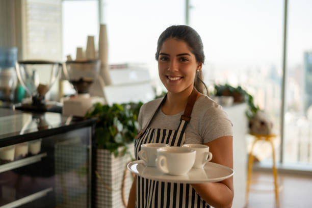 istock Beautiful young waitress holding a tray with a coffee order at a cafeteria smiling at camera 1168307444