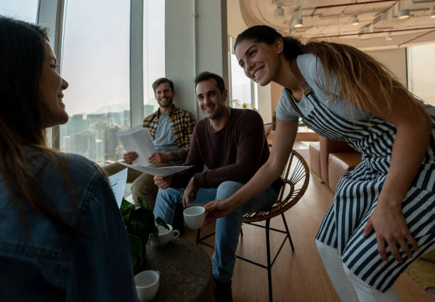 istock Friendly waitress serving a business team coffee at a coworking space all smiling 1168308133