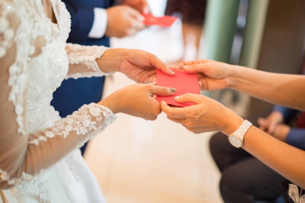 ancianos dando paquete rojo a la pareja recién casada - invitado de boda fotografías e imágenes de stock