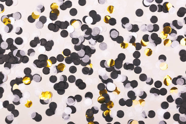 istock Black, gold and white confetti on grey background. 1168310956