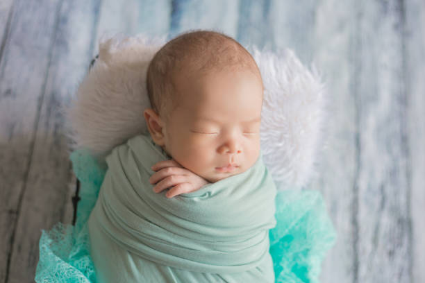 Adorable newborn baby sleeping in cozy room. Adorable newborn baby sleeping in cozy room. Cute happy infant baby portrait with sleepy face in bed. Soft focus at the baby eyes. Newborn nursery care concept. Only Baby Girls stock pictures, royalty-free photos & images