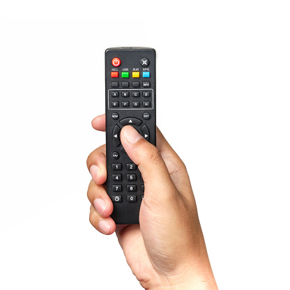 La mano está sosteniendo el control remoto de la televisión. photo