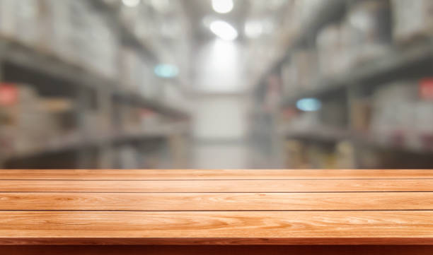 istock Wood table in warehouse storage blur background with empty copy space on the table for product display mockup. Hardware goods distribution and industrial logistics concept. 1168322128