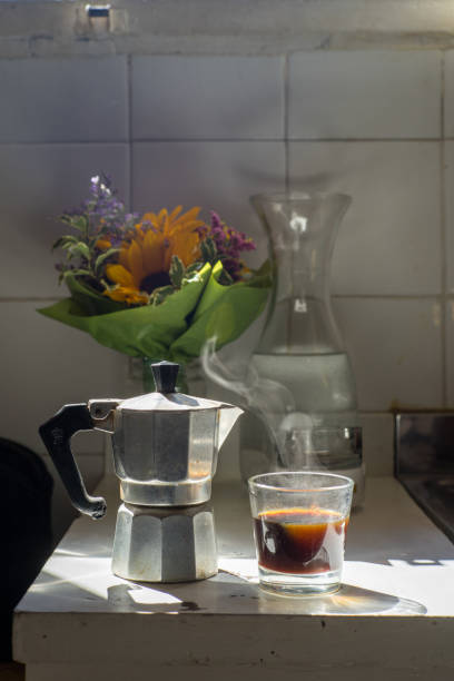 istock Italian Moka pot coffee maker and hot black coffee in kitchen with sunlight 1168323891