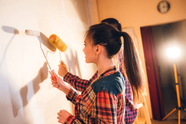 istock Young couple painting wall 1168327882