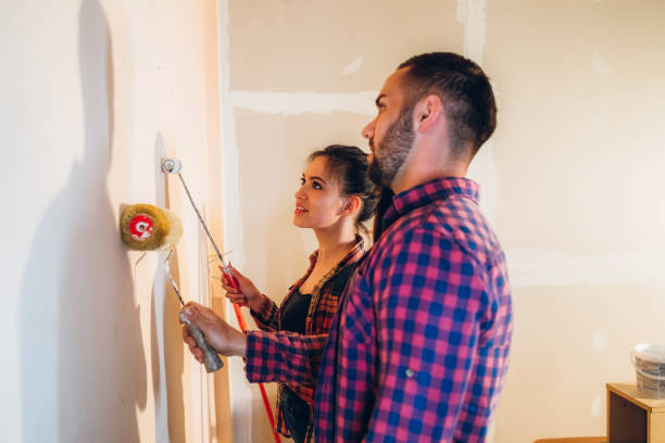 istock Young couple painting wall 1168327886